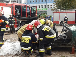 Strażacy wyciągają poszkodowanego z rozbitego samochodu